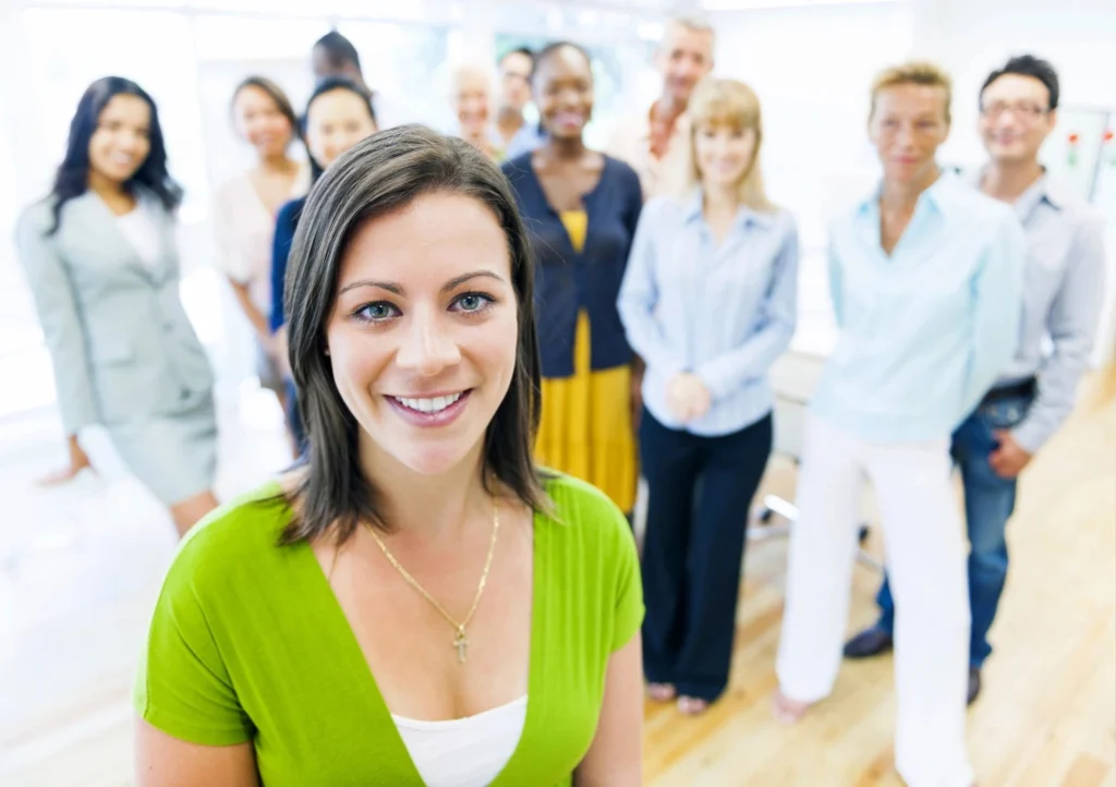 A group of people standing in a room with one woman smiling.
