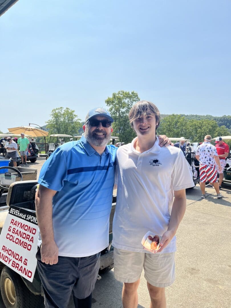 Two men standing next to each other in a parking lot.